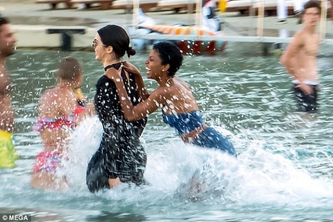 Kendal şampan şüşəsi və qısa libasda dənizə girdi